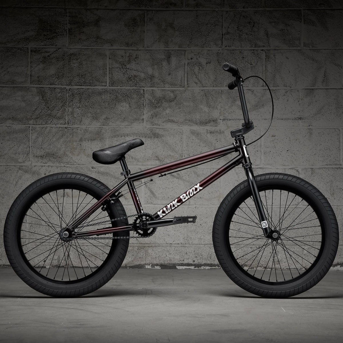 BMX bike with dark frame and red stripes, side profile with front handbrake