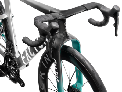 Road bike detail view of handlebars, front wheel, and teal frame accents