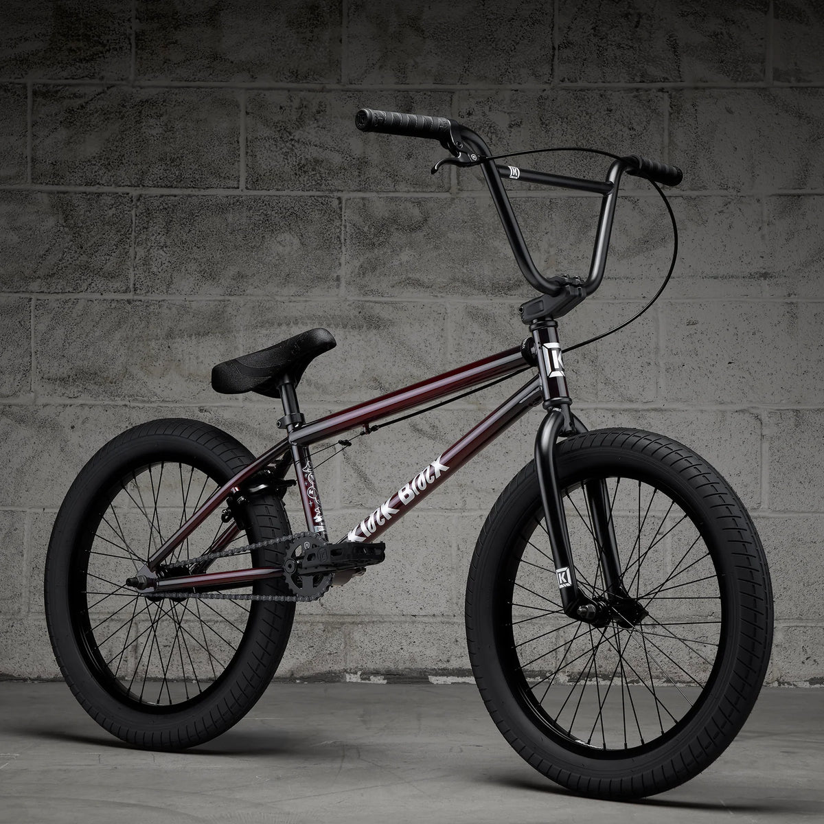 BMX bike with black frame and red accents, side view with knobby tires