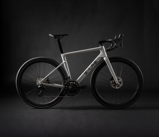 White road bike with drop handlebars, disc brakes, and black wheels