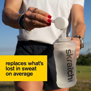 Skratch Labs hydration sports drink mix bottle with powder being poured into a cup