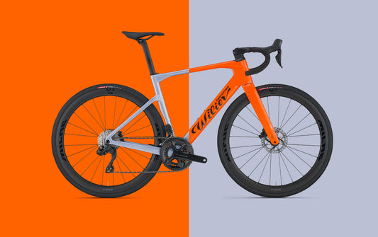 Orange and silver carbon road bike with disc wheels and drop handlebars